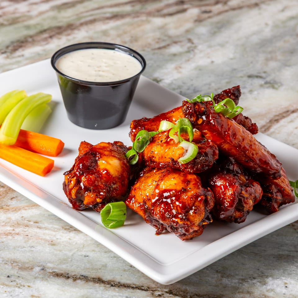 Big John's Eatery's southern-style BBQ chicken wings with celery, carrots, and ranch dressing.